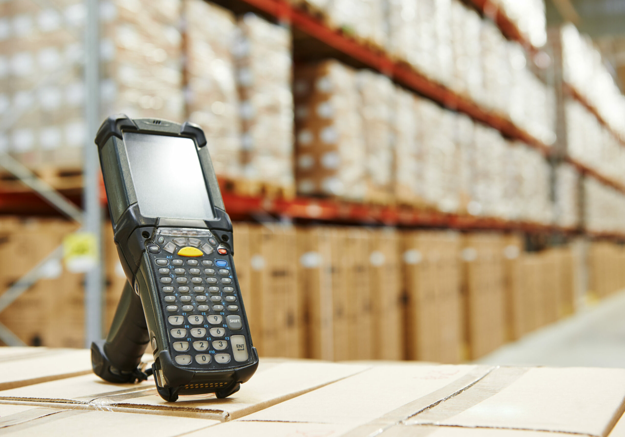Bluetooth barcode scanner in front of modern warehouse